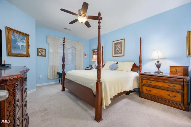 a spacious bedroom with a bed and a chandelier
