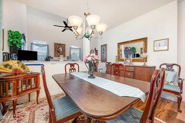 a view of a dining room with furniture a chandelier and wooden floor