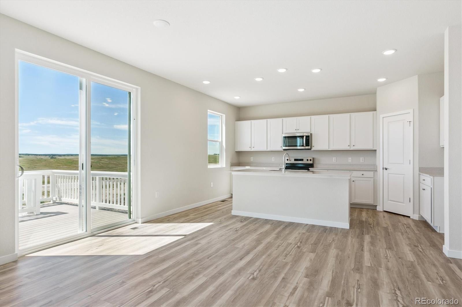 4235 Gozzer Ranch Drive Elizabeth, CO 80107 - Photo 5 of 23 a kitchen with wooden floors and white cabinets