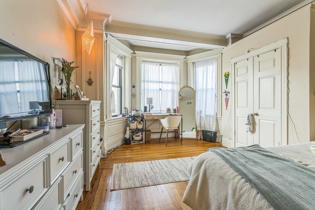 466 Commonwealth Avenue, Unit 301 Boston, MA 02215 - Photo 4 of 14 a spacious bedroom with a bed a table and large mirror