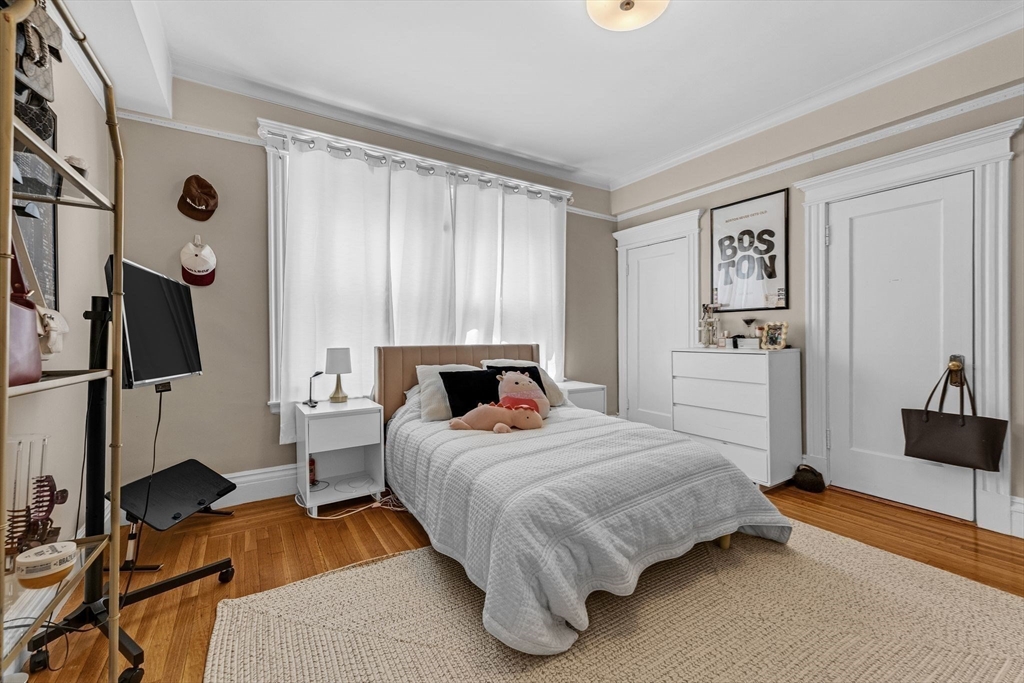 466 Commonwealth Avenue, Unit 301 Boston, MA 02215 - Photo 5 of 14 a bedroom with a bed and a flat tv screen on the dresser