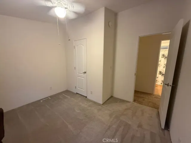 an empty room with chandelier fan