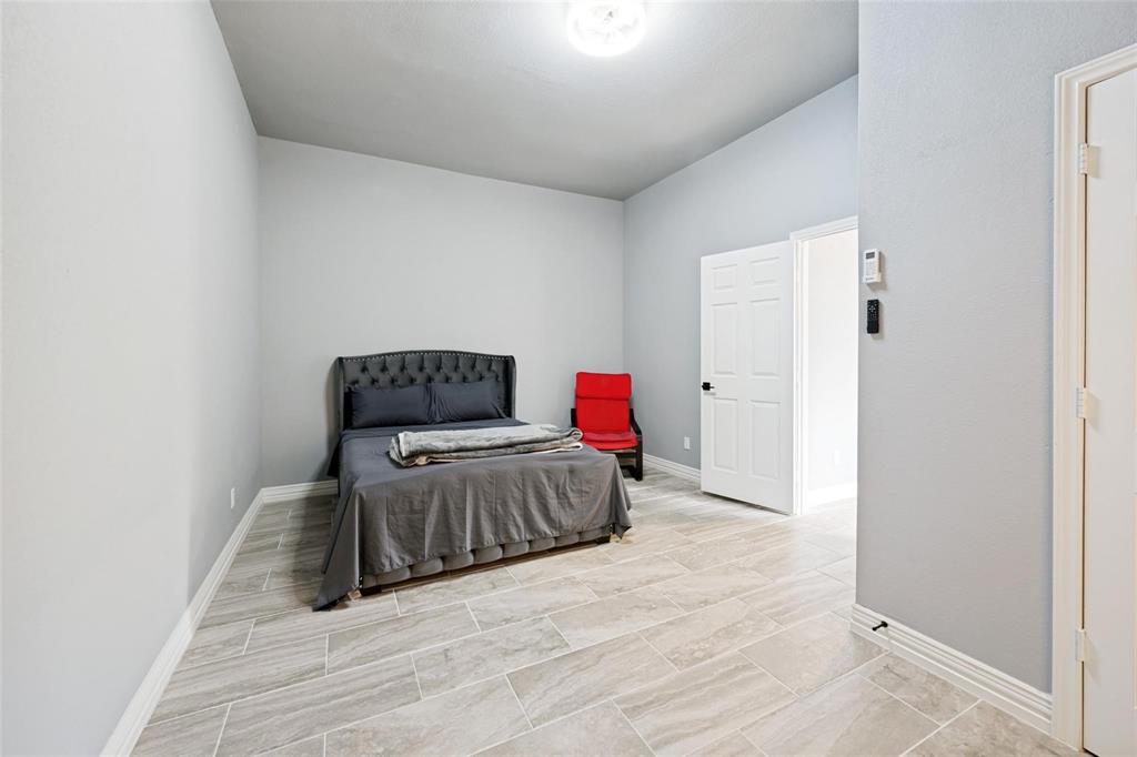 818 Riviera Drive Mansfield, TX 76063 - Photo 12 of 24 Spacious room featuring light gray walls, large format tile flooring, white baseboards, and a white six-panel door