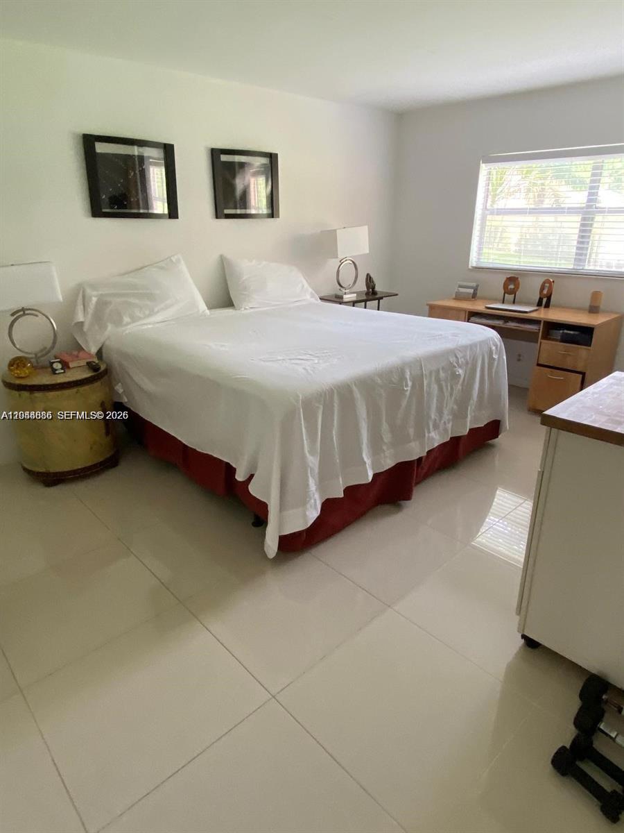 8838 West McNab Road, Unit 104 Tamarac, FL 33321 - Photo 11 of 23 a bedroom with a bed and a couch