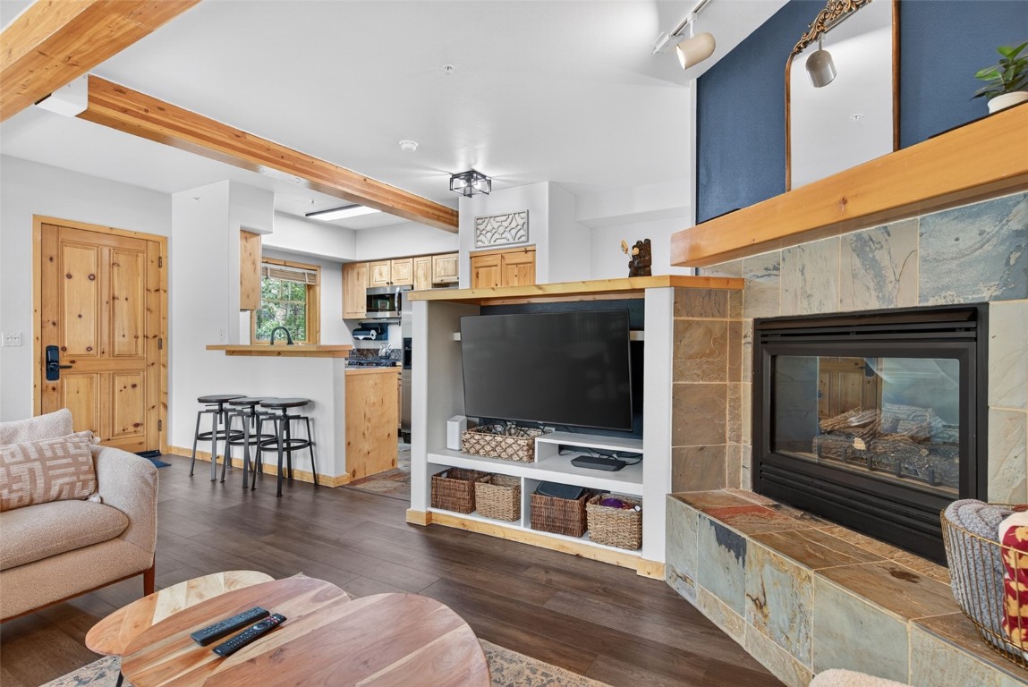 260 Ski Hill Road, Unit 6 Breckenridge, CO 80424 - Photo 5 of 25 Living area featuring beamed ceiling, dark wood-type flooring, and a fireplace