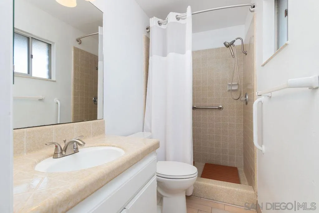 6778 West Lilac Road Bonsall, CA 92003 - Photo 17 of 45 a bathroom with a granite countertop sink toilet and shower