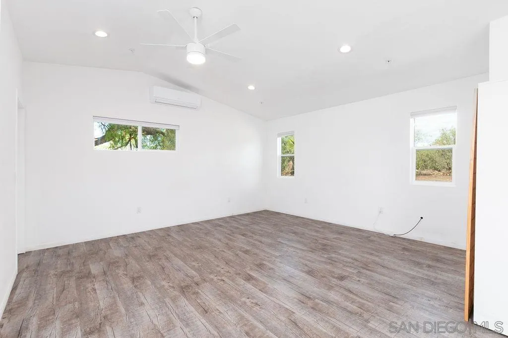 6778 West Lilac Road Bonsall, CA 92003 - Photo 24 of 45 an empty room with wooden floor and windows