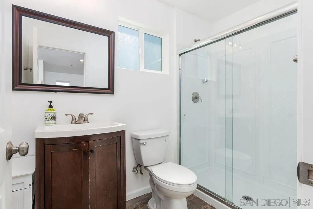 6778 West Lilac Road Bonsall, CA 92003 - Photo 25 of 45 a bathroom with a toilet a sink a vanity and mirror