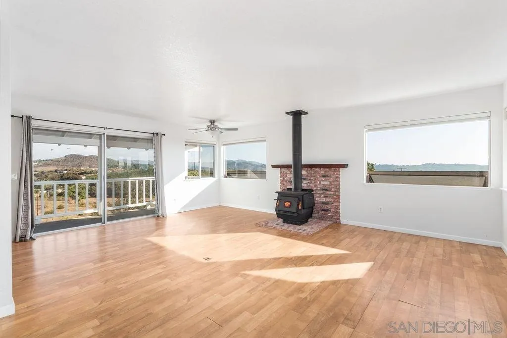 6778 West Lilac Road Bonsall, CA 92003 - Photo 31 of 45 a view of a livingroom with wooden floor and a flat screen tv