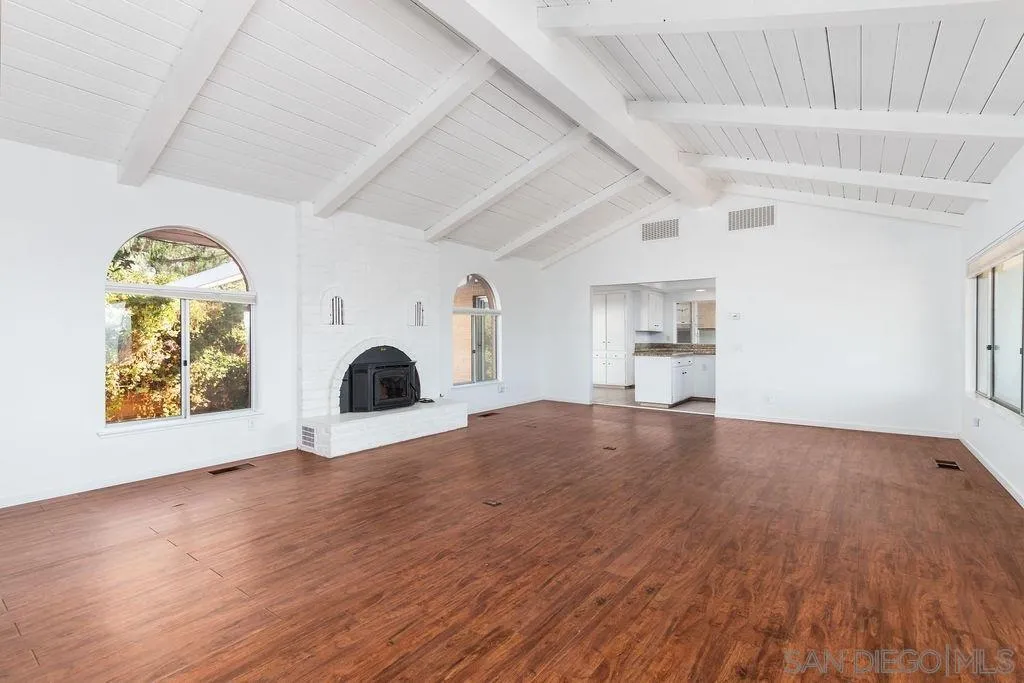 6778 West Lilac Road Bonsall, CA 92003 - Photo 6 of 45 a view of empty room with a fireplace and wooden floor