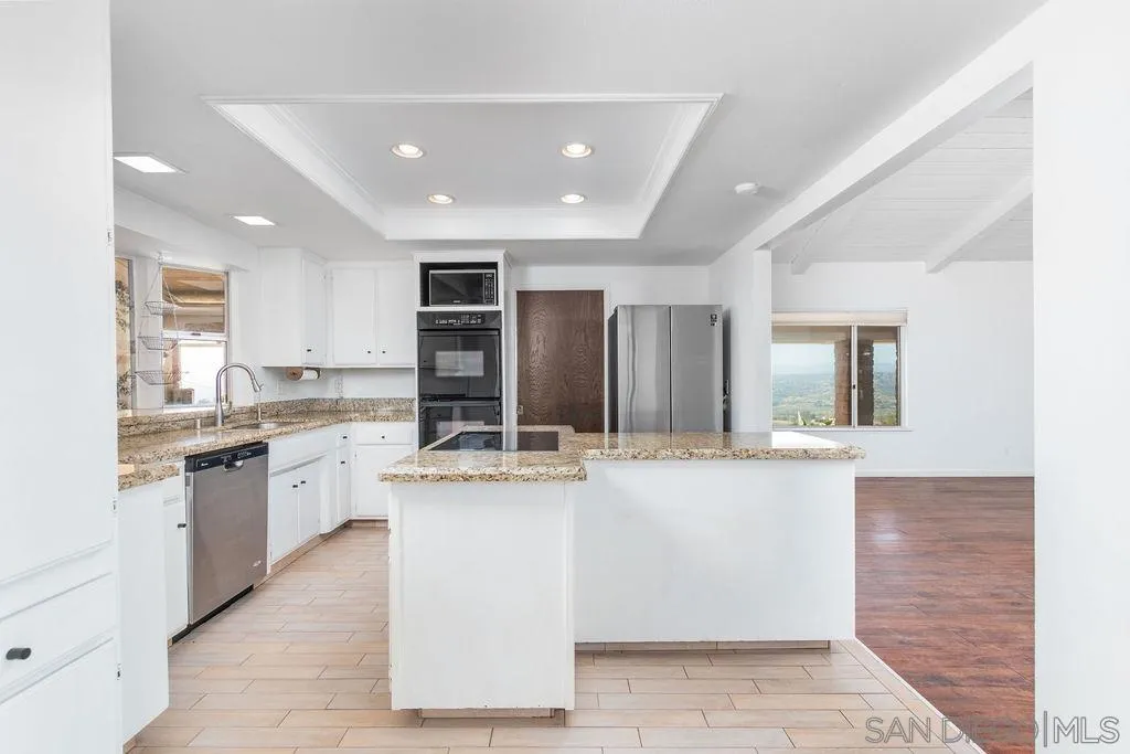 6778 West Lilac Road Bonsall, CA 92003 - Photo 9 of 45 a kitchen with stainless steel appliances kitchen island granite countertop a sink and cabinets