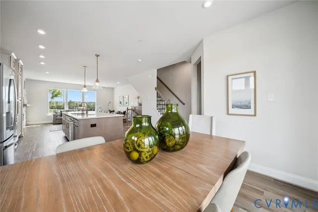 a view of a dining room with furniture a potted plant and wooden floor