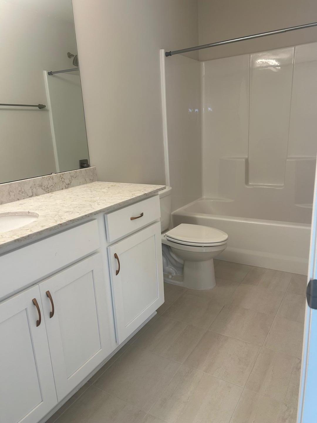 1024 Gateway Commons Circle Wake Forest, NC 27587 - Photo 13 of 18 a bathroom with a granite countertop sink toilet and shower