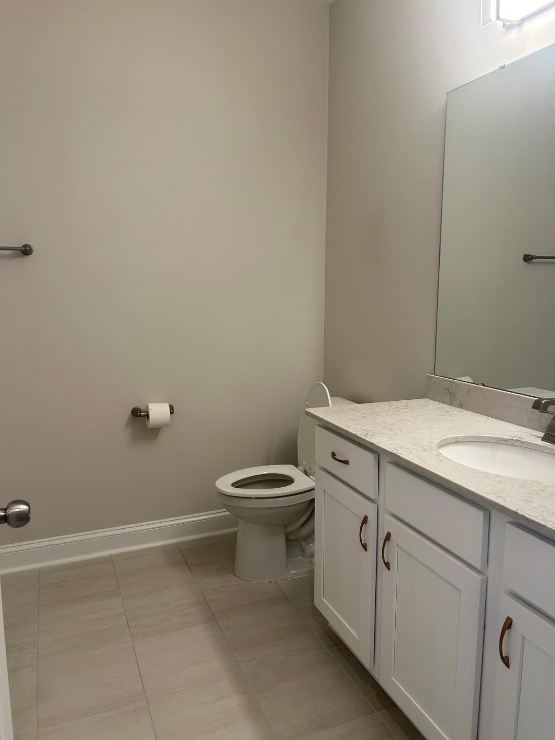 1024 Gateway Commons Circle Wake Forest, NC 27587 - Photo 4 of 18 a bathroom with a granite countertop toilet and a sink