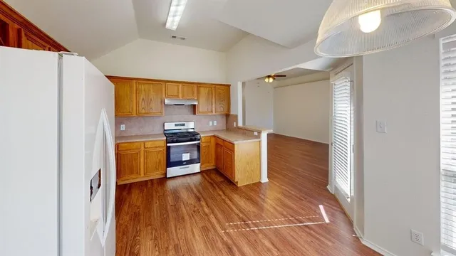 a kitchen with stainless steel appliances a refrigerator and a stove top oven