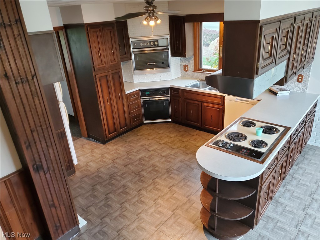 5530 Manchester Road Akron, OH 44319 - Photo 9 of 24 Kitchen featuring light parquet floors, backsplash, ceiling fan, white appliances, and dark brown cabinetry