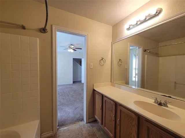 a en suite bathroom with a granite countertop sink and a mirror