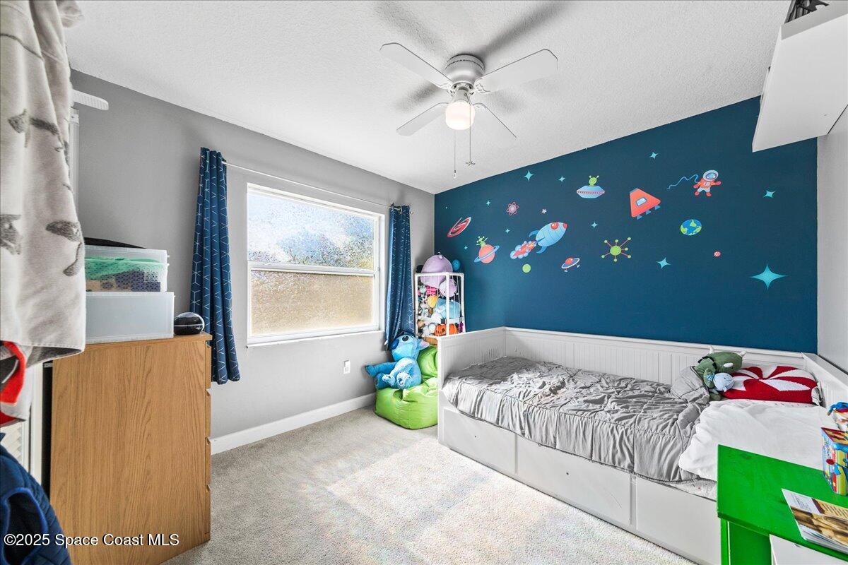 985 Sycamore Drive Rockledge, FL 32955 - Photo 18 of 26 a bedroom with a bed and a chandelier