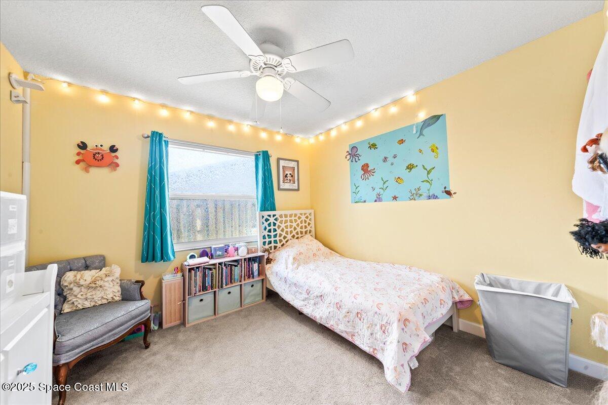 985 Sycamore Drive Rockledge, FL 32955 - Photo 19 of 26 a bedroom with a bed painting on wall and a large window