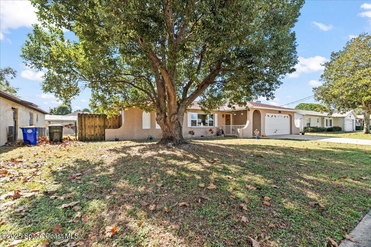 985 Sycamore Drive Rockledge, FL 32955 - Photo 22 of 26 a front view of a house with a large tree