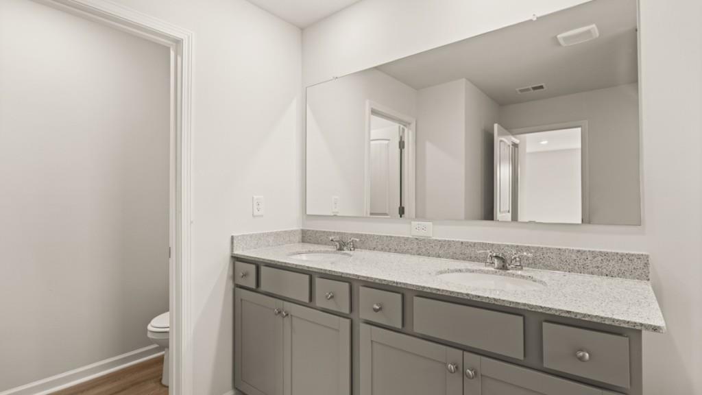 703 Anchor Avenue Villa Rica, GA 30180 - Photo 24 of 32 a bathroom with a granite countertop sink and a mirror