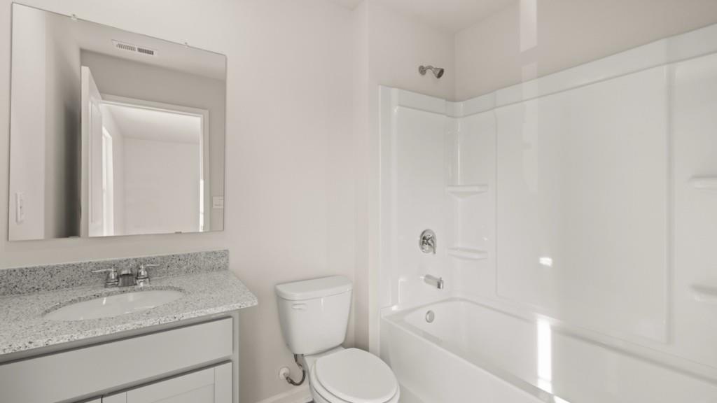 703 Anchor Avenue Villa Rica, GA 30180 - Photo 27 of 32 a bathroom with a granite countertop sink toilet and shower