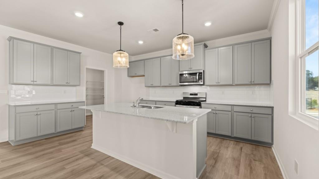 703 Anchor Avenue Villa Rica, GA 30180 - Photo 10 of 32 a kitchen with kitchen island white cabinets and white appliances