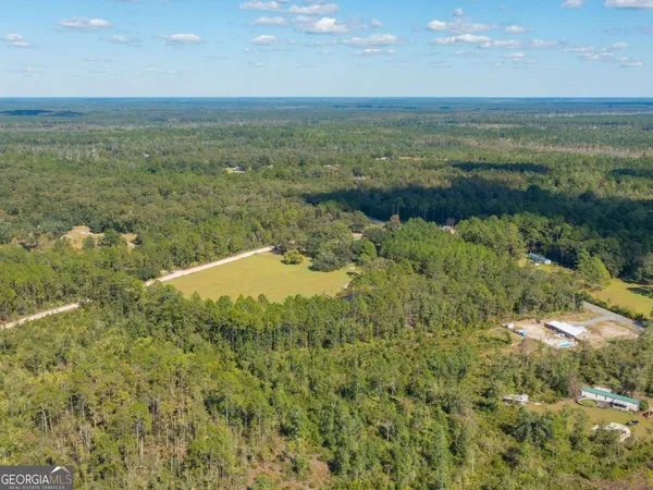 a view of a lake with beach and green space