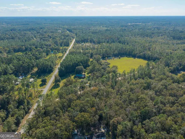 a view of a green field with mountains in the background