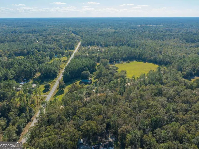 a view of a green field with mountains in the background