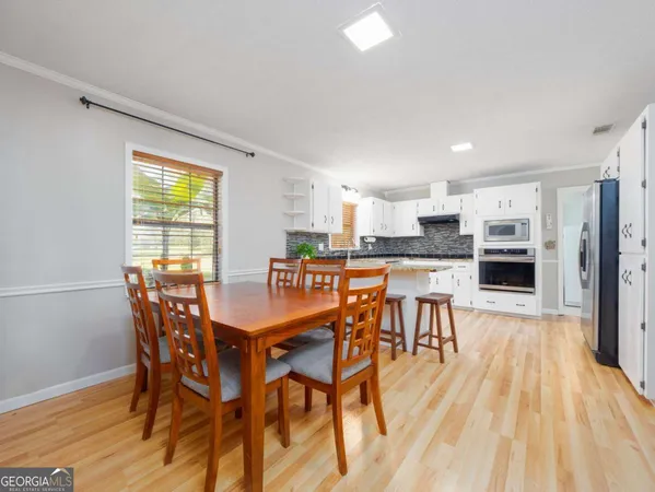 a kitchen with granite countertop white cabinets and white appliances