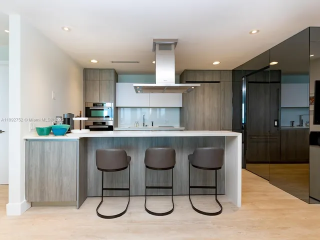 a kitchen with stainless steel appliances granite countertop a table and chairs in it