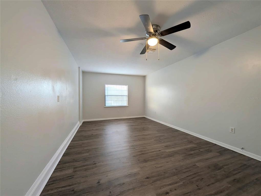 1511 Southwest Shorewood Drive Dunnellon, FL 34431 - Photo 15 of 31 a view of an empty room with wooden floor and a ceiling fan