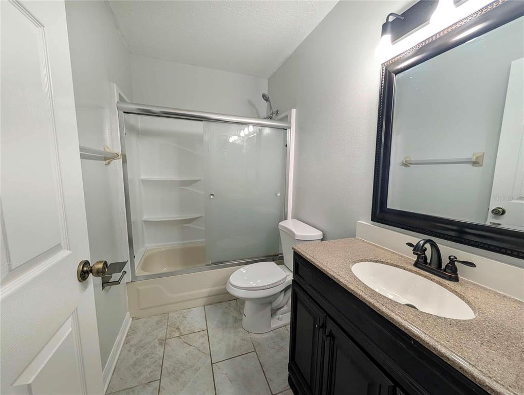 1511 Southwest Shorewood Drive Dunnellon, FL 34431 - Photo 23 of 31 a bathroom with a granite countertop sink toilet mirror and a shower
