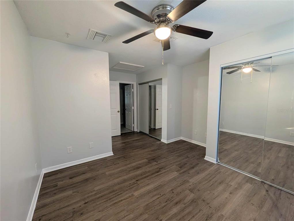 1511 Southwest Shorewood Drive Dunnellon, FL 34431 - Photo 6 of 31 an empty room with wooden floor chandelier fan and closet