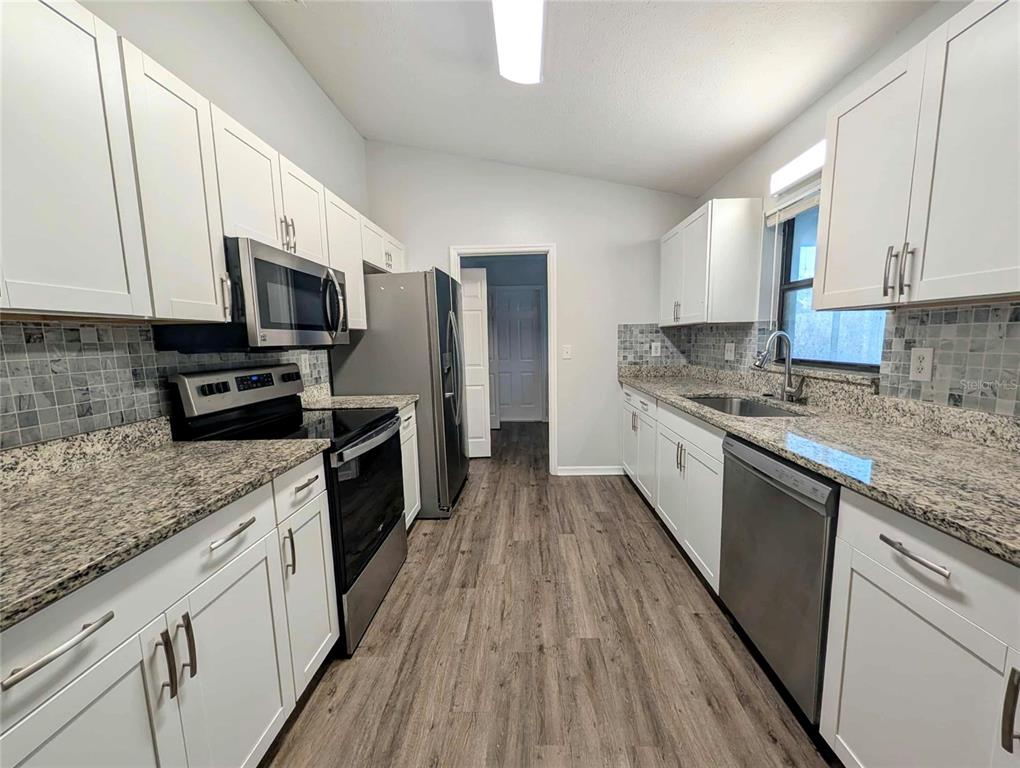 1511 Southwest Shorewood Drive Dunnellon, FL 34431 - Photo 9 of 31 a kitchen with stainless steel appliances wooden cabinets granite counter tops a stove a sink and a refrigerator
