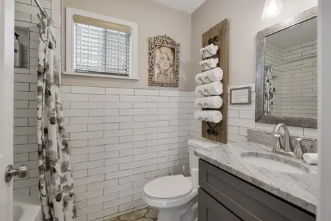 a bathroom with a granite countertop toilet sink and mirror