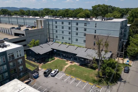 an aerial view of a house with a garden and lake view