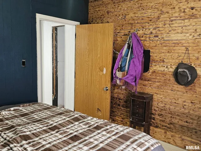 a bedroom with a bed and a wooden floor