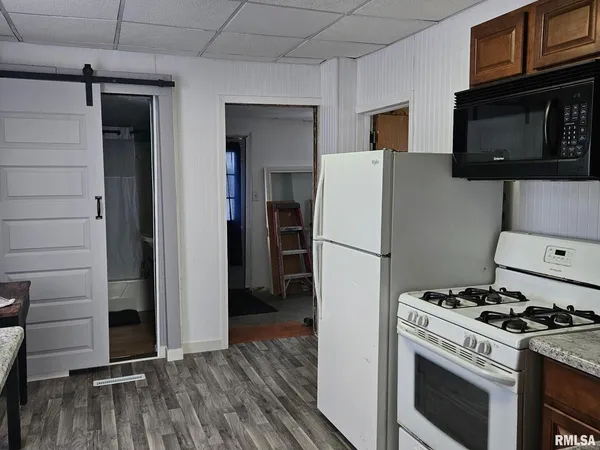 a kitchen with a stove a refrigerator and a microwave