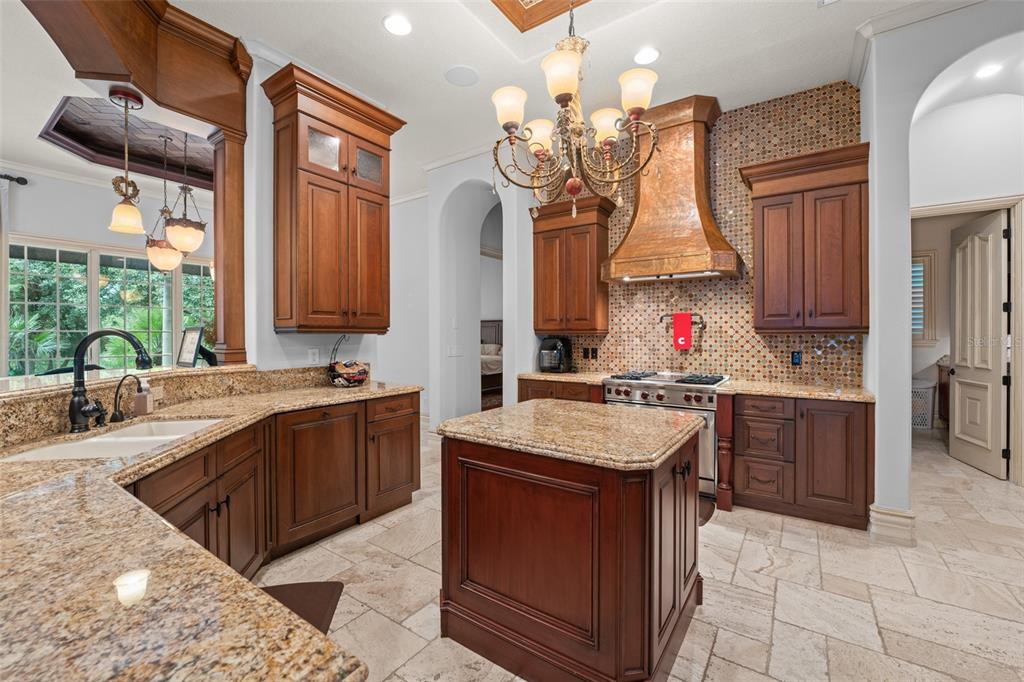 4812 Alexandra Garden Court Windermere, FL 34786 - Photo 12 of 65 a kitchen with a sink stove and wooden cabinets