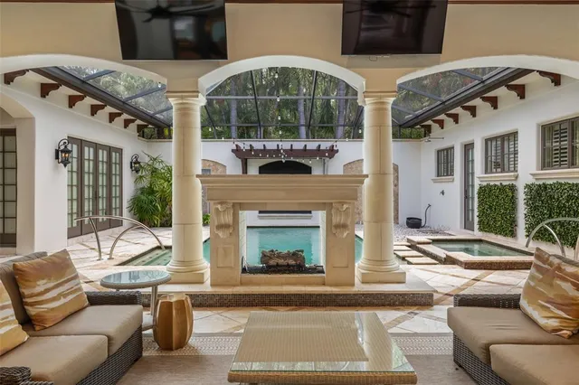 a living room with furniture a fireplace and a floor to ceiling window