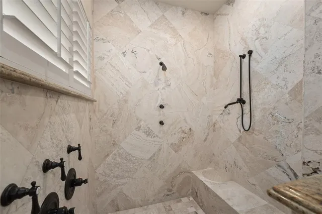 a bathroom with a granite countertop sink a mirror and a shower
