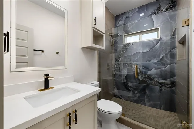 a bathroom with a sink a toilet and shower