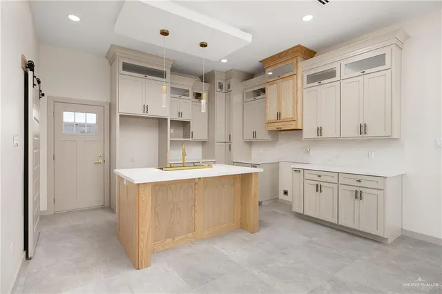 a kitchen with stainless steel appliances kitchen island granite countertop a refrigerator and a sink