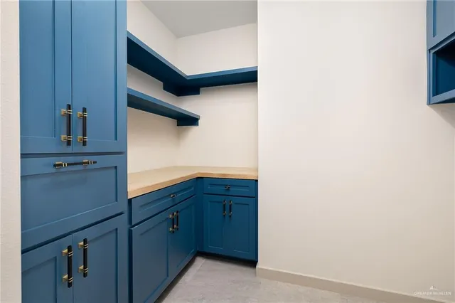 a kitchen that has a lot of white cabinets and stainless steel appliances