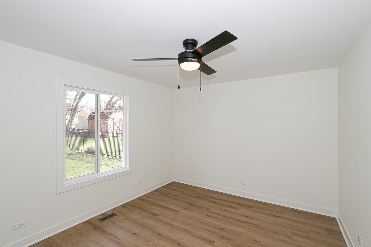 464 Winterwood Drive Roselle, IL 60172 - Photo 18 of 39 a view of empty room with wooden floor and fan