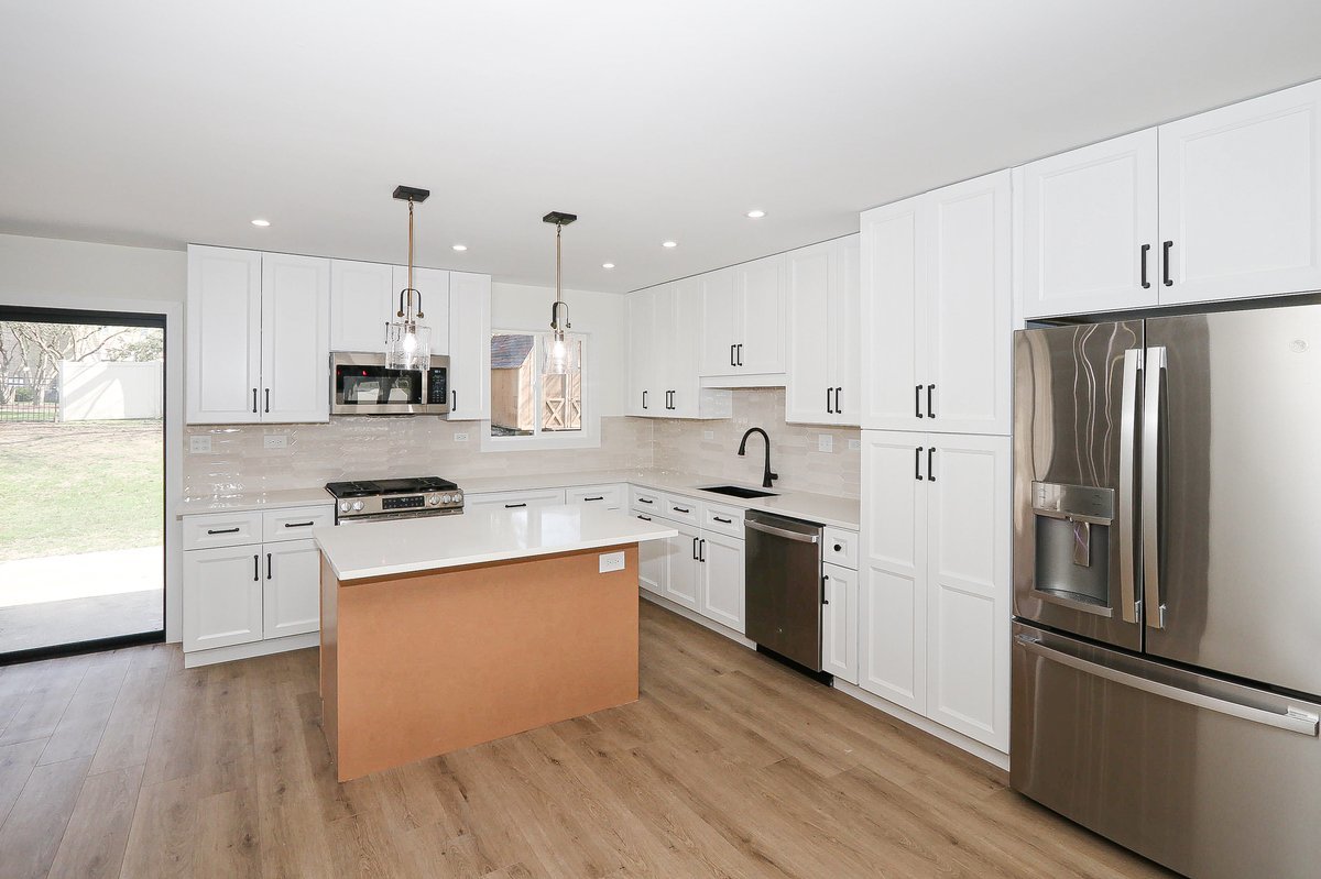 464 Winterwood Drive Roselle, IL 60172 - Photo 5 of 39 a kitchen with stainless steel appliances a refrigerator a sink dishwasher a stove top oven a refrigerator and white cabinets with wooden floor