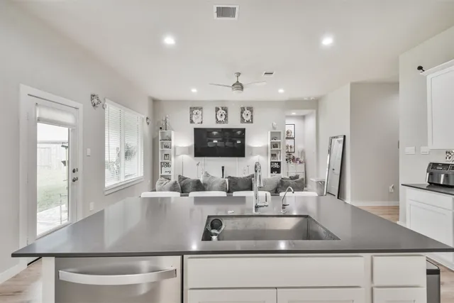 a kitchen with kitchen island a sink stainless steel appliances and windows