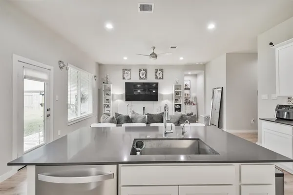 a kitchen with kitchen island a sink stainless steel appliances and windows